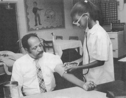 A young girl uses a modern blood pressure measuring instrument. Today, home versions of this device are widely available.